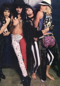 the band kiss posing for a photo in front of a wall with graffiti on it