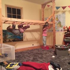 two children are playing in a room with bunk beds and other things on the floor