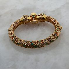 Unique Jeweled Bangle Jewelry, Ceremonial Multicolor Hallmarked Jewelry, Unique Festive Jewelry Bracelet, Yellow Gold Jeweled Temple Jewelry, Temple Jewelry Yellow Gold Bangle, Hand Set Temple Jewelry Bracelet, Unique Multicolor Bangle Jewelry, Ceremonial Fine Jewelry With Hand Set Details, Unique Round Jeweled Jewelry