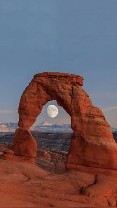 the moon is setting over arches and rocks