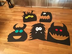 cut out monsters on the floor with eyes and mouth shapes in front of their faces