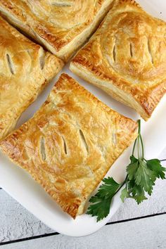 four pieces of pie on a plate with parsley sprigs next to it