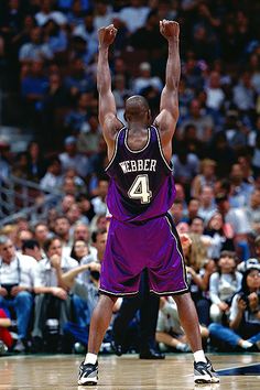 a basketball player raising his arms in the air