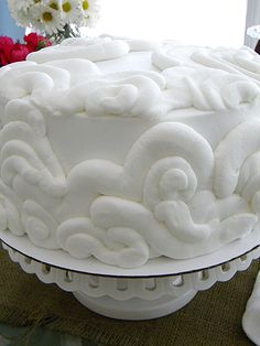 a cake with white frosting sitting on top of a table