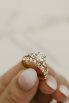 a person holding an engagement ring in their hand