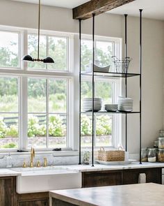 a kitchen filled with lots of counter top space next to a large white sink and window