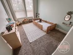 a baby's room with a crib and toys on the carpeted floor