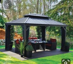 a black gazebo sitting on top of a lush green field