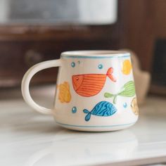 "🐟 Dive into the Artistry of the Underwater World with \"Aquatic Symphony\" Fish Mug - A Vibrant Celebration of Marine Life! 🐟 Immerse yourself in the vibrant beauty of the ocean's inhabitants with our \"Aquatic Symphony\" Fish Mug. Handcrafted with meticulous care, this mug isn't just a vessel for your drinks; it's a colorful homage to the enchanting world of fish, designed to bring a piece of the marine spectacle into your daily life. 👤 Who Should Buy \"Aquatic Symphony\" Fish Mug? Marine L Sea Themed Pottery Painting, Painting Ideas On Ceramics, Painted Mug Designs, Fish Pottery Painting, Hand Painted Pottery Mugs, Ocean Pottery, Fish Mug, Fun Mugs, Mug Pottery