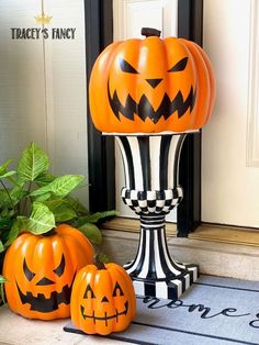 two pumpkins sitting on top of a black and white pedestal