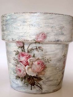 an old white bucket with pink roses painted on it