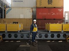 a man standing in front of some cargo containers