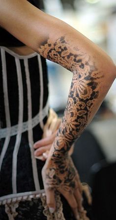 a woman's arm covered in black and white tattoos