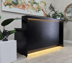 a black reception table with lights on the side and plants in pots next to it