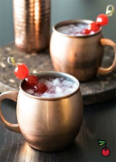 a copper mug filled with ice and cherries