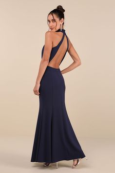 a woman in a long blue dress with open back