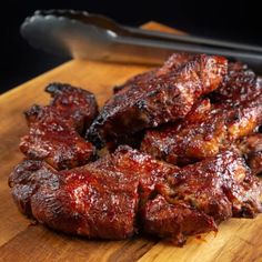 barbecue ribs on a cutting board next to a knife