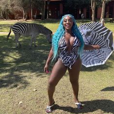 a woman in a zebra print swimsuit holding an umbrella