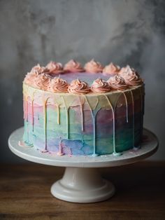 a rainbow cake with icing dripping down the side