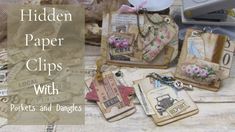 altered paper clips with tags and magnets are displayed on a wooden table next to an old sewing machine