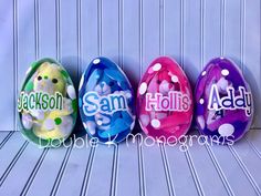 three decorated easter eggs sitting on top of a wooden table with the words sam's written on them