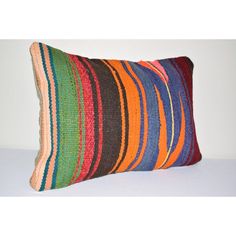 a multicolored striped pillow sitting on top of a white table