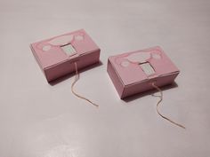 two pink boxes sitting on top of a table