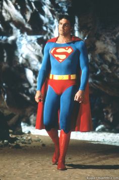 a man dressed as superman standing in front of some rocks