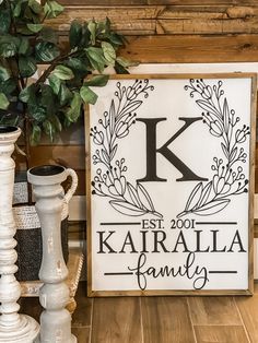 there is a sign that says kalarialia family next to some vases and a potted plant