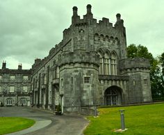 an old castle like building sitting on top of a lush green field