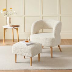 a white chair and foot stool in a room