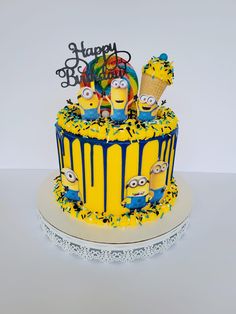 a yellow and blue birthday cake with minion decorations