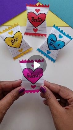 someone holding up some paper hearts with the words best friends written on them in different colors