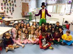 a group of children sitting on the floor in front of a man with a top hat and cane