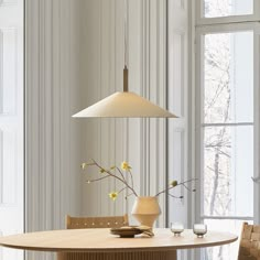 a dining room table with two chairs and a vase on the table next to it