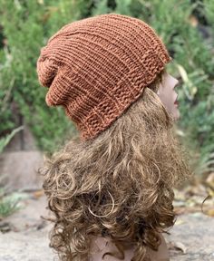 a close up of a person wearing a knitted hat on top of their head