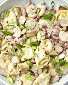 a white bowl filled with pasta and meat