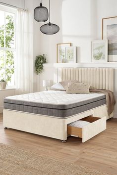 a bed with two drawers underneath it in a room next to a window and rug