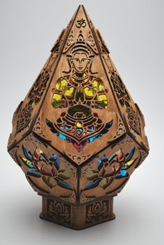 an intricately designed wooden object with colorful lights on it's face and hands