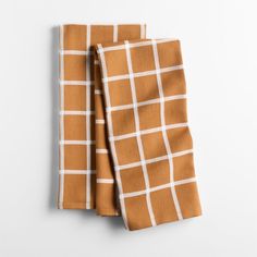 an orange and white checkered napkin on a white background