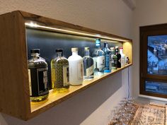 a wooden shelf filled with bottles and glasses