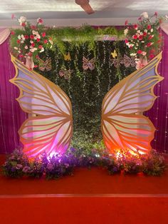 a decorated stage with flowers and butterfly wings