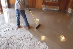 a man is cleaning the floor with a broom