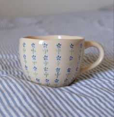 a white cup with blue flowers on it