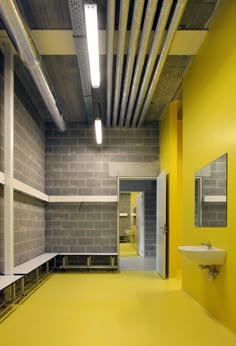 an empty room with yellow walls and white shelves on either side of the wall is a sink and mirror