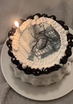 a cake on a plate with a lit candle in the middle and an image of a tree