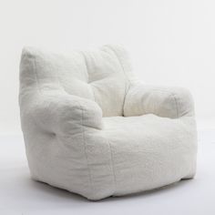 a white bean bag chair sitting on top of a white floor next to a wall