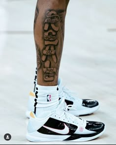 a man with tattoos on his leg and sneakers in the foreground is wearing nike shoes