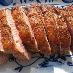 sliced meat on a blue and white plate