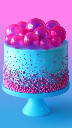 a cake with pink and blue icing on it, topped with lots of balls